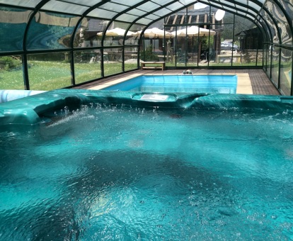 Foto de la piscina cubierta y el jacuzzi del spa del hotel.