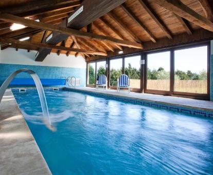 Foto de la piscina interior con elementos de hidroterapia disponible todo el año.