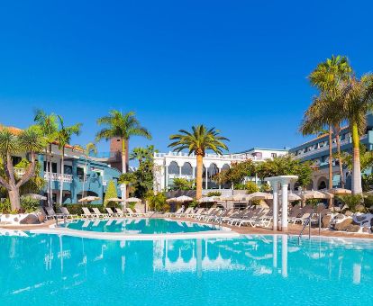 Hotel solo para adultos con amplias piscinas exteriores y solarium con tumbonas.