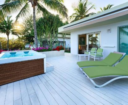 Terraza con mobiliario y jacuzzi privado al aire libre de la suite con vistas al mar del hotel.