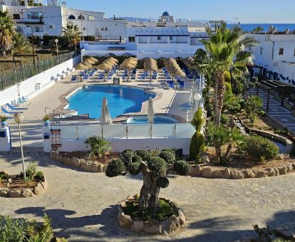 Zona exterior con piscina y mobiliario de este hotel solo para adultos cerca de la playa.