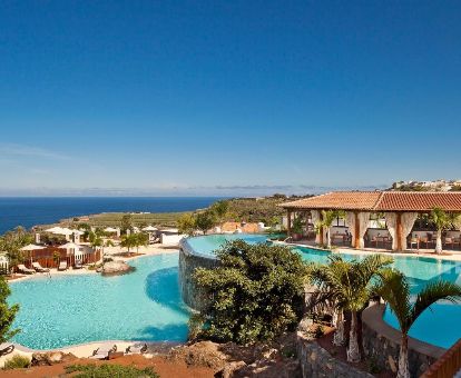 Exteriores con piscinas al aire libre, terrazas con mobiliario y vistas al mar de este hotel solo para adultos.