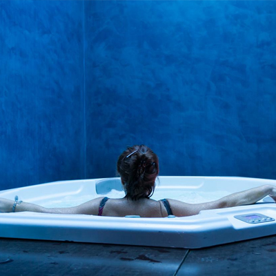 Foto del jacuzzi con una iluminación azul y una mujer de espaldas en el Hotel Viento 10 de Córdoba