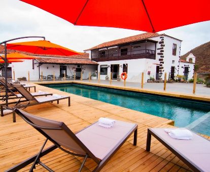 Terraza solarium con piscina y mobiliario de este hotel solo para adultos.