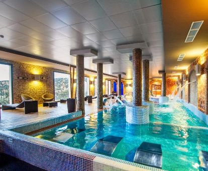 Piscina cubierta con elementos de hidroterapia del centro de bienestar de este hotel romántico.