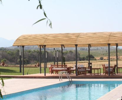 Zona exterior con amplios jardines con piscina al aire libre y mobiliario de este hotel rural.