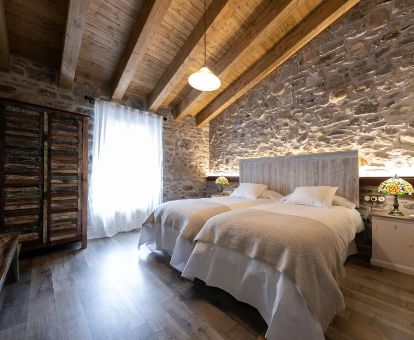 Una de las cómodas habitaciones con paredes de piedra a la vista de este hotel solo para adultos.