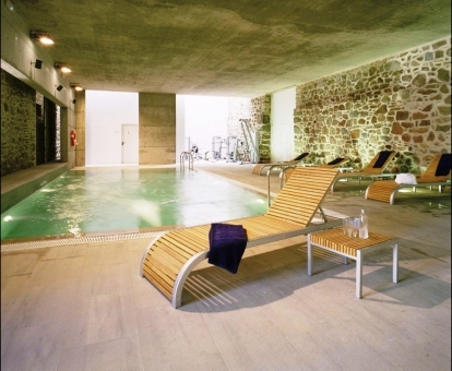 Foto de la piscina cubierta con zona de relajación del spa.