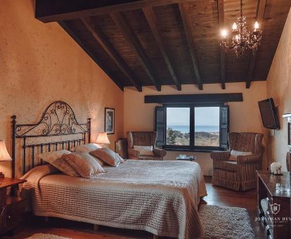 Una de las hermosas habitaciones de estilo tradicional de este hotel con vistas al paisaje natural y al mar.