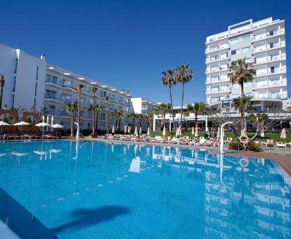 Hotel solo para adultos con amplia piscina al aire libre y solarium con tumbonas.