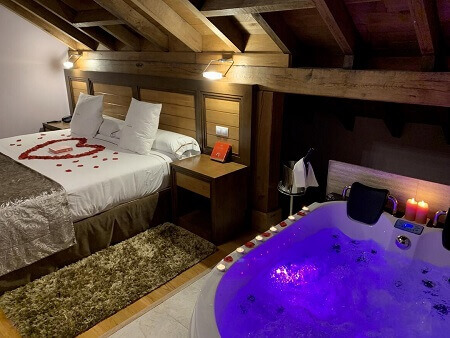 Foto de una hotel con suite para parejas con jacuzzi en la habitación junto a la cama ideal para ir con tu pareja