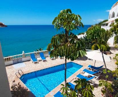 Foto de la piscina al aire libre con solarium y vistas al mar.