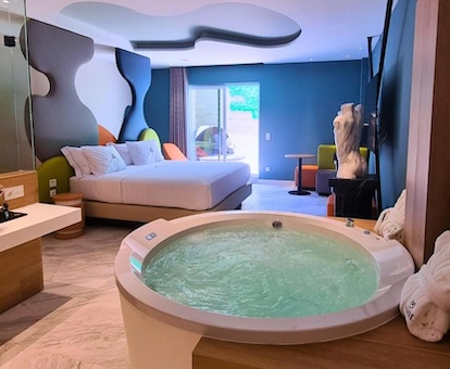 Foto del jacuzzi de la suite con hidromasaje circular con la cama al fondo en la habitación con decoración temática