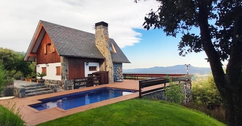Foto de la casa rural con chimenea junto a la piscina en la parte alta de una colina con vistas al campo y la montaña