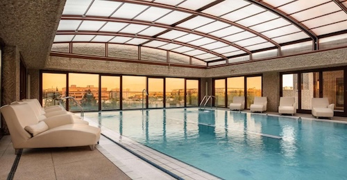 Foto de la piscina cubierta climatizada con una serie de asientos y tumbonas en los laterales en el Hotel Hilton de Madrid Airport